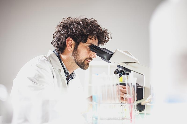 Biotech scientist looking through microscope